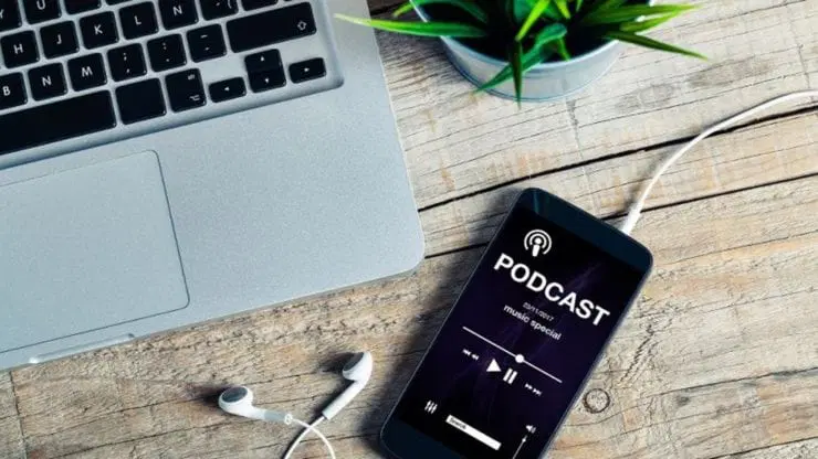 Nghe podcast trên điện thoại bên góc làm việc